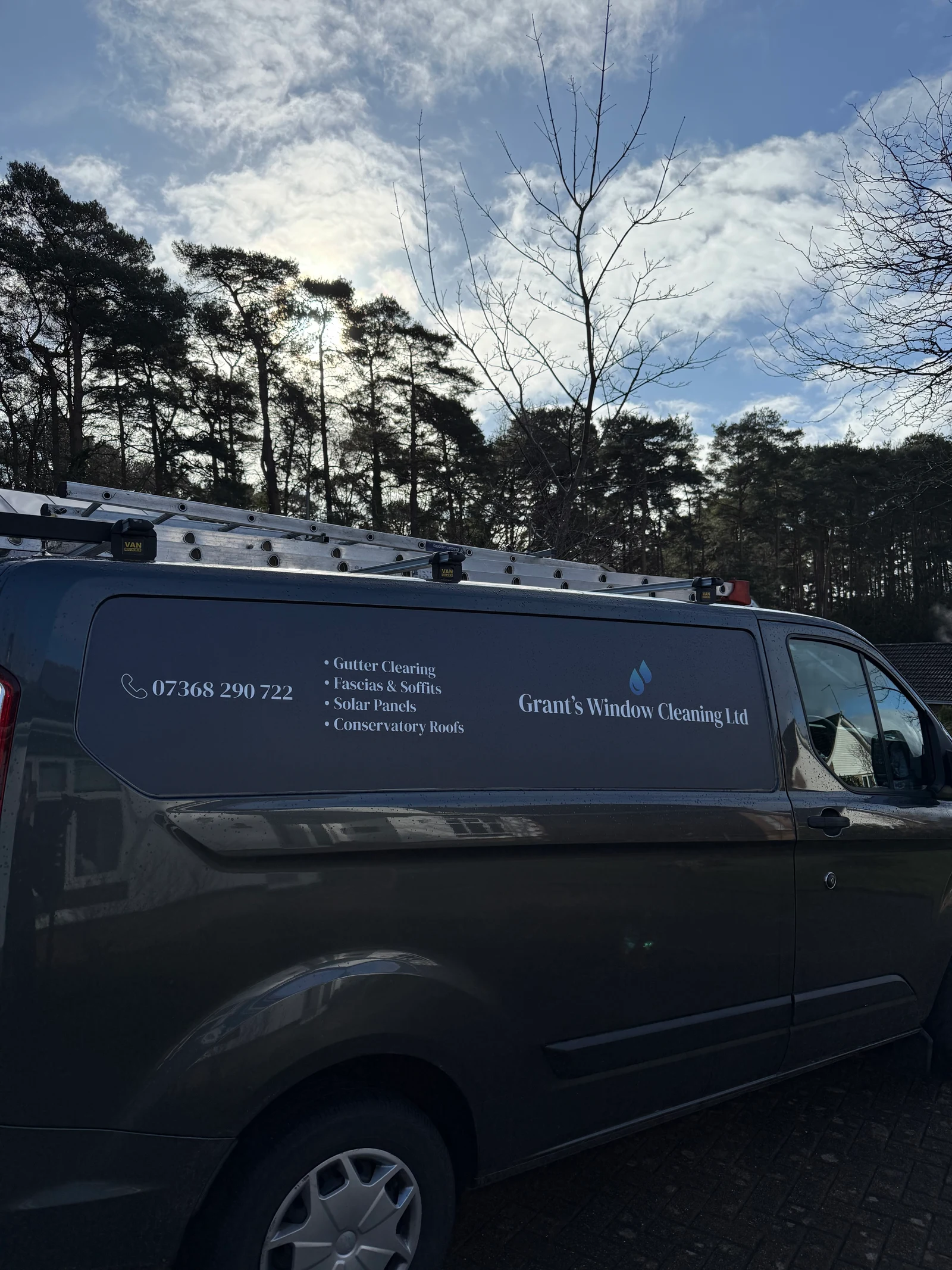 The fully equipped Grant's Window Cleaning van, sign-written with the services offered and the contact number